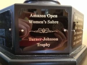 The base of a trophy reading "Amazon Open Women's Sabre Turner-Johnson Trophy"