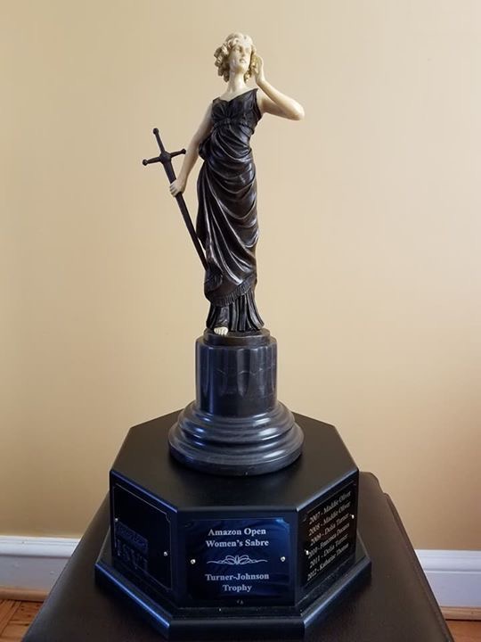 A trophy with the figurine of a woman on top, holding a sword.